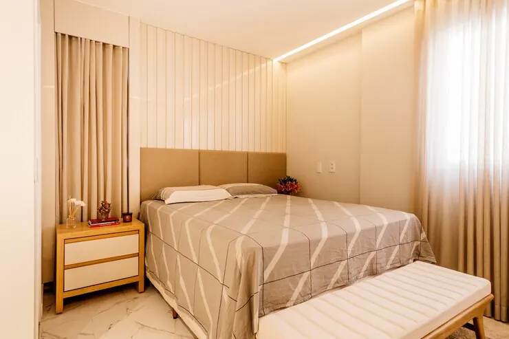 A bedroom with a flat white ceiling and a hidden LED light line along the wall